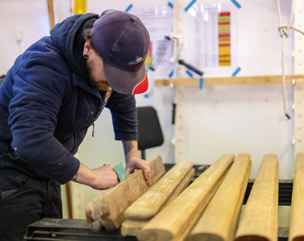 A maintenance team member sanding wooden handrails from Britannia. 
