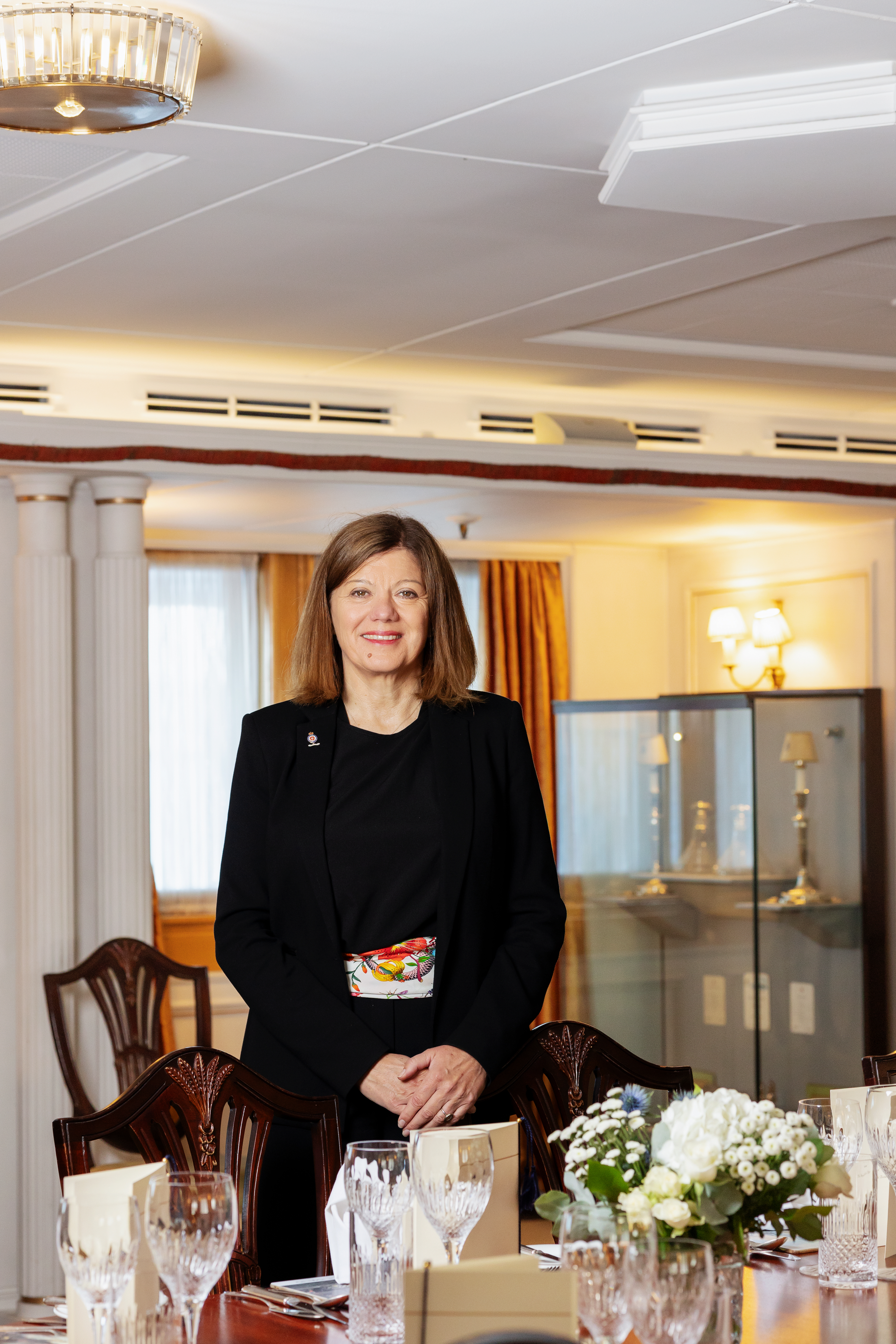 Woman standing at a dining room table for a portrait