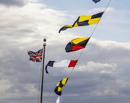 Colourful dress flags flying in the wind above Britannia. 