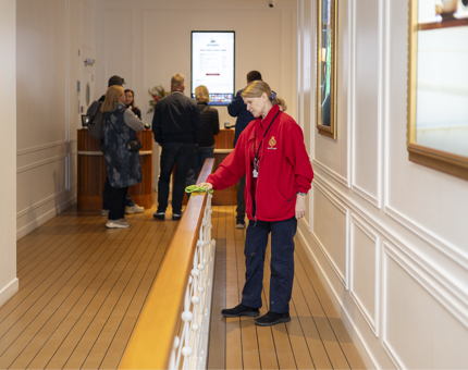 A Housekeeper wiping a handrail in the Visitor Centre entrance. 