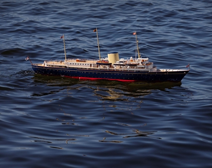 A replica model of Britannia sailing in the water.