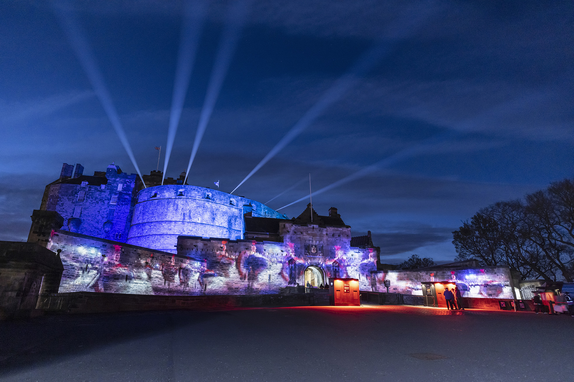 Edinburgh Castle at night. It is lit up with images projected onto it.