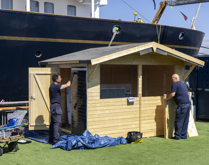 Two men building a wooden hut on the Quayside next to Britannia in Leith. 