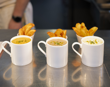 Mugs of soup and bowls of potato wedges from the Tearoom. 