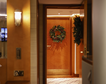 A view from a cabin into the hallway aboard Fingal Hotel. The doors have Christmas wreaths on them. 