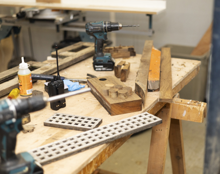Inside the Maintenance workshop, wood is cut to different lengths. 