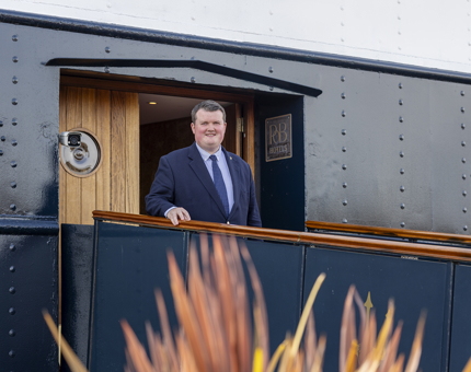 At the entrance to Fingal Hotel in Edinburgh, a man stands with his hand on the railing.
