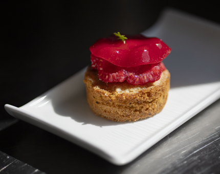 A small cake with raspberries on top of it.