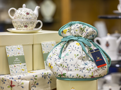 A selection of the embroidery range of products in the Gift Shop. There is a tea set, tea cosy, tea towels. 