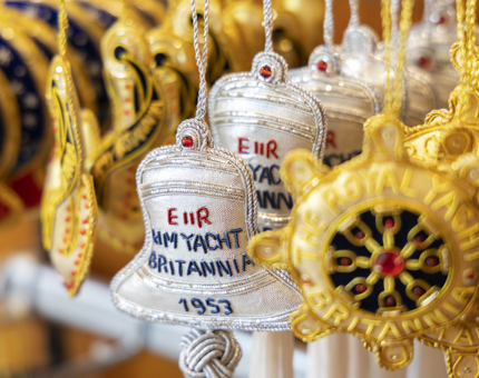 Embroidered hanging decorations in the shape of the Britannia Bell and ship's wheel. 