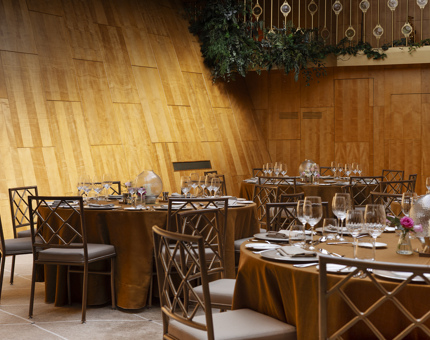 Fingal's Ballroom, round tables are set with gold coloured tables cloths. 