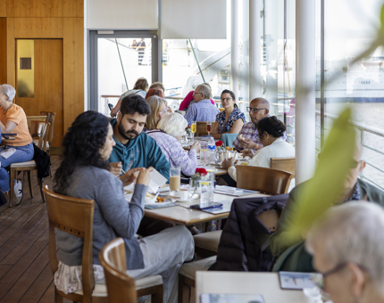 Visitors enjoying the menu in the Royal Deck Tearoom with views over the Port of Leith.