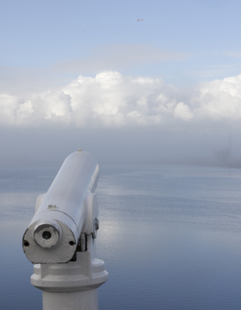 A telescope looking out over a view across the water at Leith. 