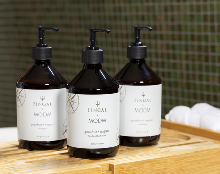Three bottles of MODM bath and body products displayed in a bathroom aboard Fingal Hotel in Leith. 