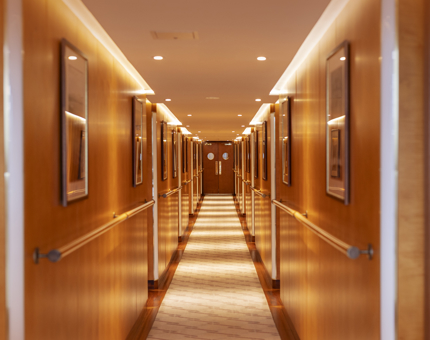 A wood panelled corridor on Fingal. The walls are lined with pictures of lighthouses. 