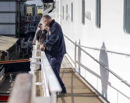 Maintenance team members installing a handrail on deck. 