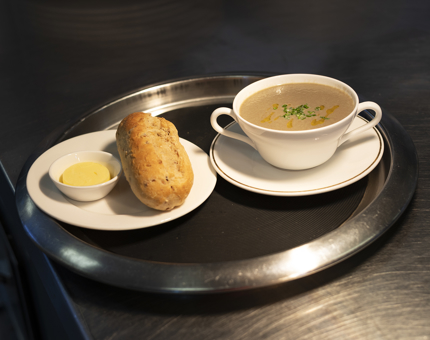 A bowl Of mushroom soup and a roll on a tray ready to be served in Britannia's Galley. 