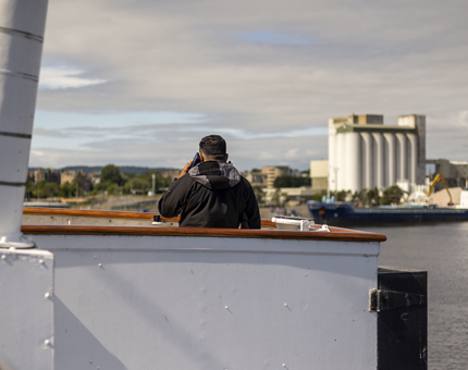 A visitor is standing on the Bridge aboard Britannia looking our into the Port of Leith. 