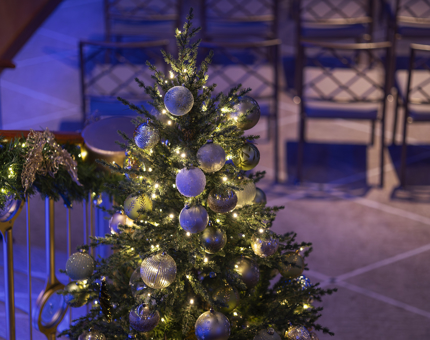 A Christmas tree is decorated and positioned next to the staircase in Fingal's Ballroom. 