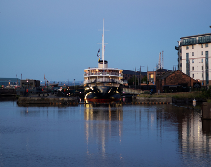 A view of Fingal Hotel docked in the Port of Leith at twilight. 