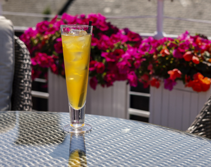 A tall iced tea on a table outside on Fingal's Deck. 