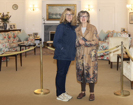 Two visitors posing for a photo in the Drawing Room aboard The Royal Yacht Britannia. 
