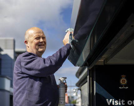A man is wiping the top of a door way at Britannia. 