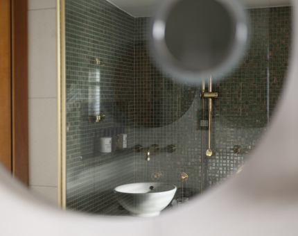 A circular mirror is reflecting an image of the bathroom in a cabin on Fingal. 