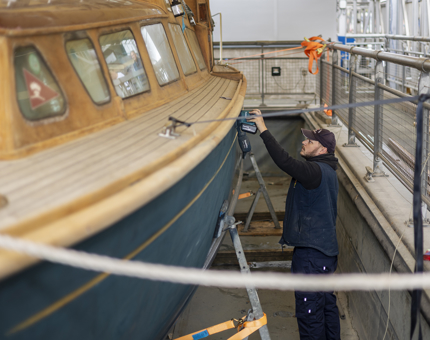 A man sanding the Royal Barge outside Britannia in Edinburgh. 
