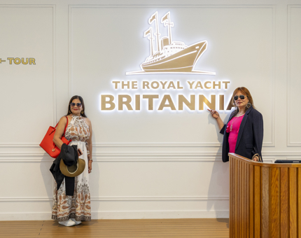 Two ladies pose at the Entrance with the gold Britannia sign before they start the tour. 