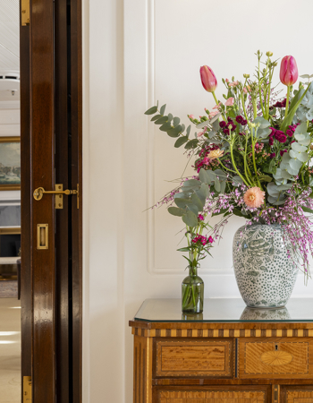 A large vase containing brightly coloured flowers in Britannia's State Ante Drawing Room. 