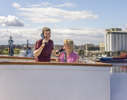 A man and a woman listening to audio handsets on The Bridge. 