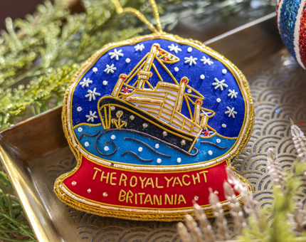 An embroidered Christmas hanging decoration that looks like a snow globe that has a picture of Britannia inside of it. 