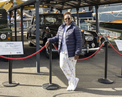 A man posing in front of the Rolls Royce and Land Rover by Britannia in the Post of Leith. 