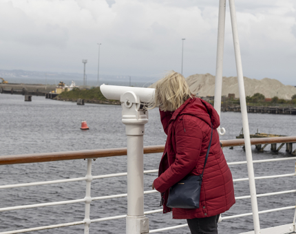 A visitor looking through telescope on the Verandah Deck.