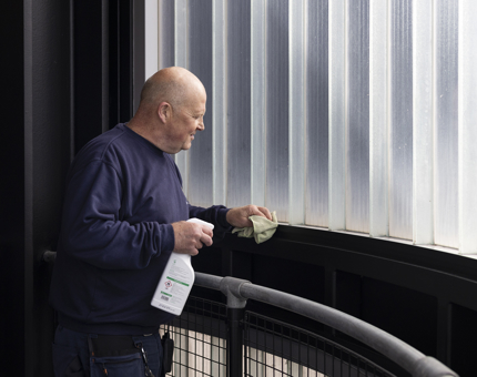 A Facilities Officer is cleaning the wall of the Lift Tower next to Britannia in Leith. 