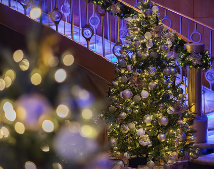 A Christmas tree is decorated and positioned next to the staircase in Fingal's Ballroom. 