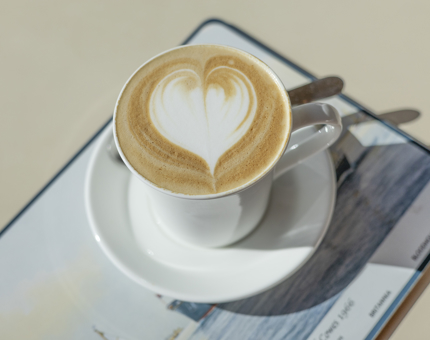 A latte is sitting on a table in the Royal Deck Tearoom. 