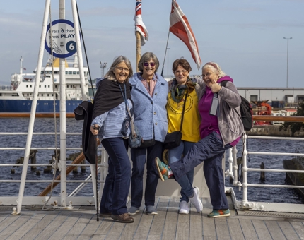 4 visitors on Verandah Deck in Leith posing for a photo. 