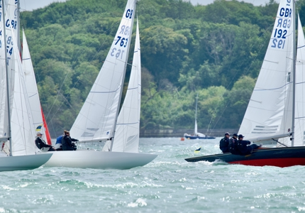Three sailboats racing on the water 