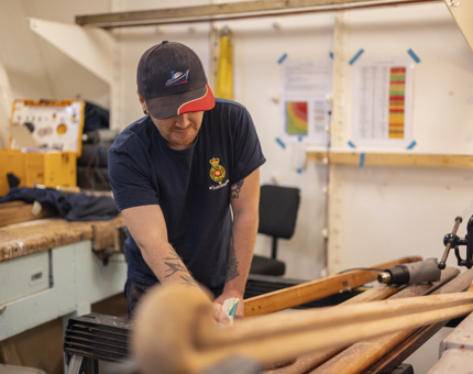 A maintenance team member sanding handrails. 
