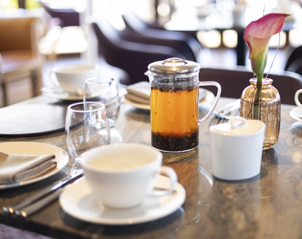A table in The Lighthouse Restaurant & Bar with cups and a pot of tea on it. 